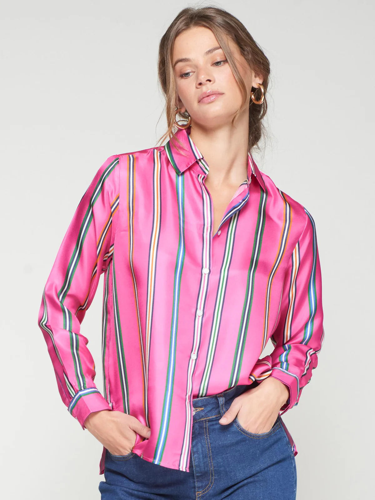 Woman wearing a pink striped shirt with a plain background