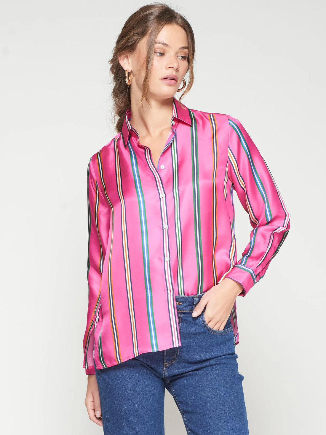 Woman wearing a pink striped shirt and blue jeans on a white background