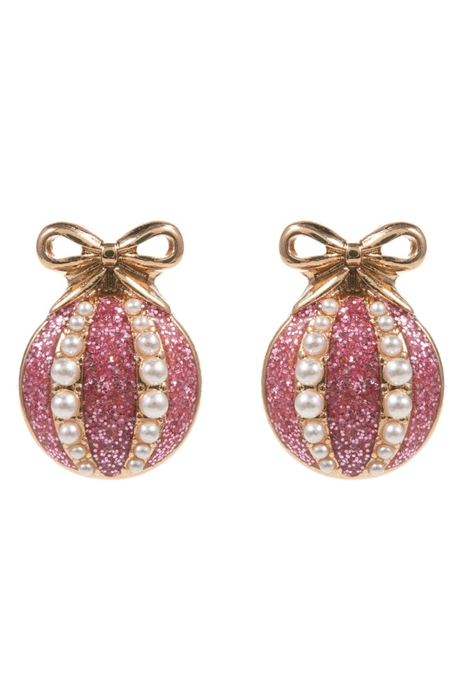 Pink glittery christmas earrings with pearl accents and gold bows on a white background