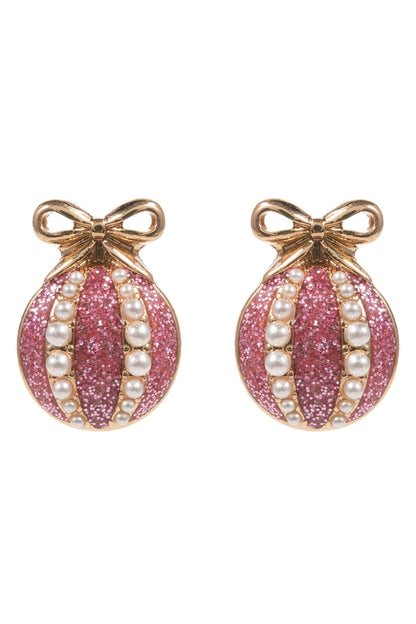 Pink glittery christmas earrings with pearl accents and gold bows on a white background