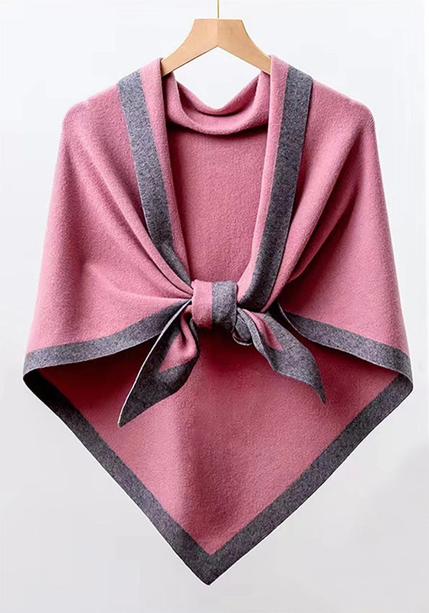 Pink poncho with gray trim on a wooden hanger against a white background