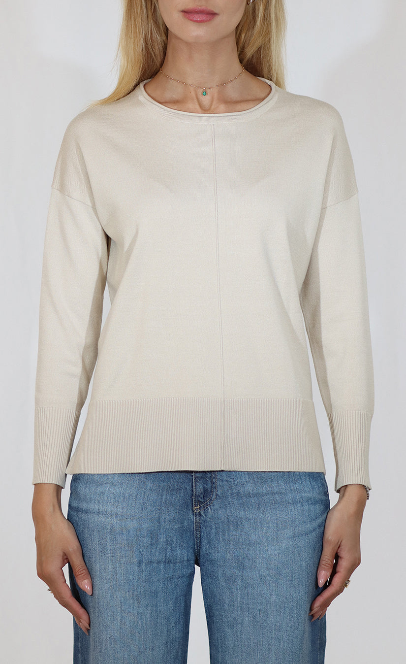 Person wearing a beige sweater and blue jeans on a white background