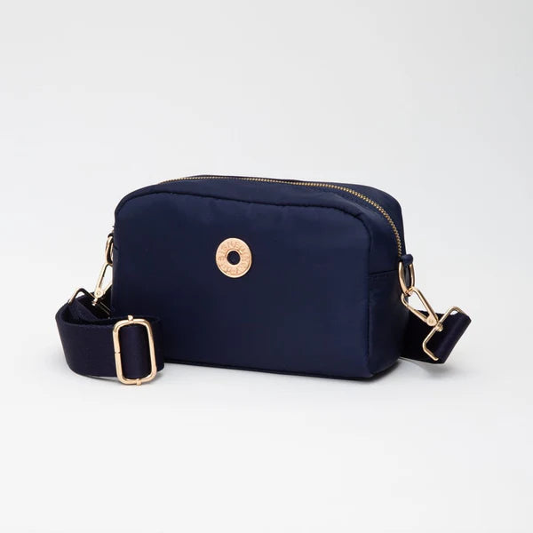 Navy blue crossbody bag with gold accents on a light gray background