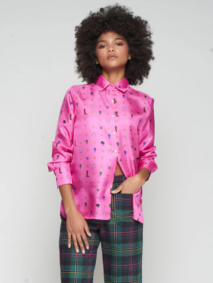 Person wearing a pink silk shirt with colorful equestrian patterns and plaid pants on a white background