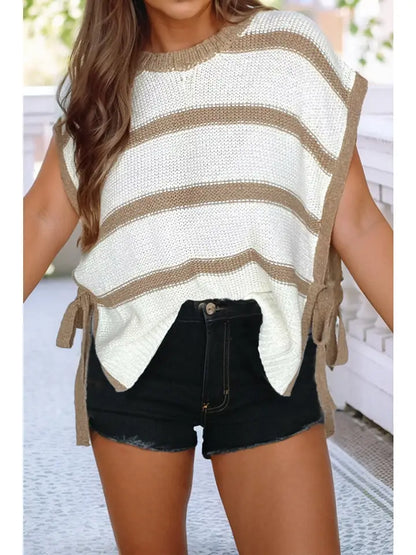 Woman wearing a striped sweater and black shorts on a blurred outdoor background