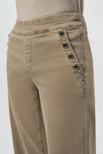 Beige pants with button details on a white background