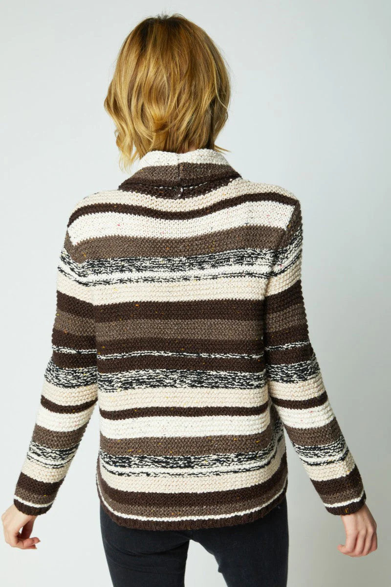 Person wearing a brown and beige striped sweater on a plain background
