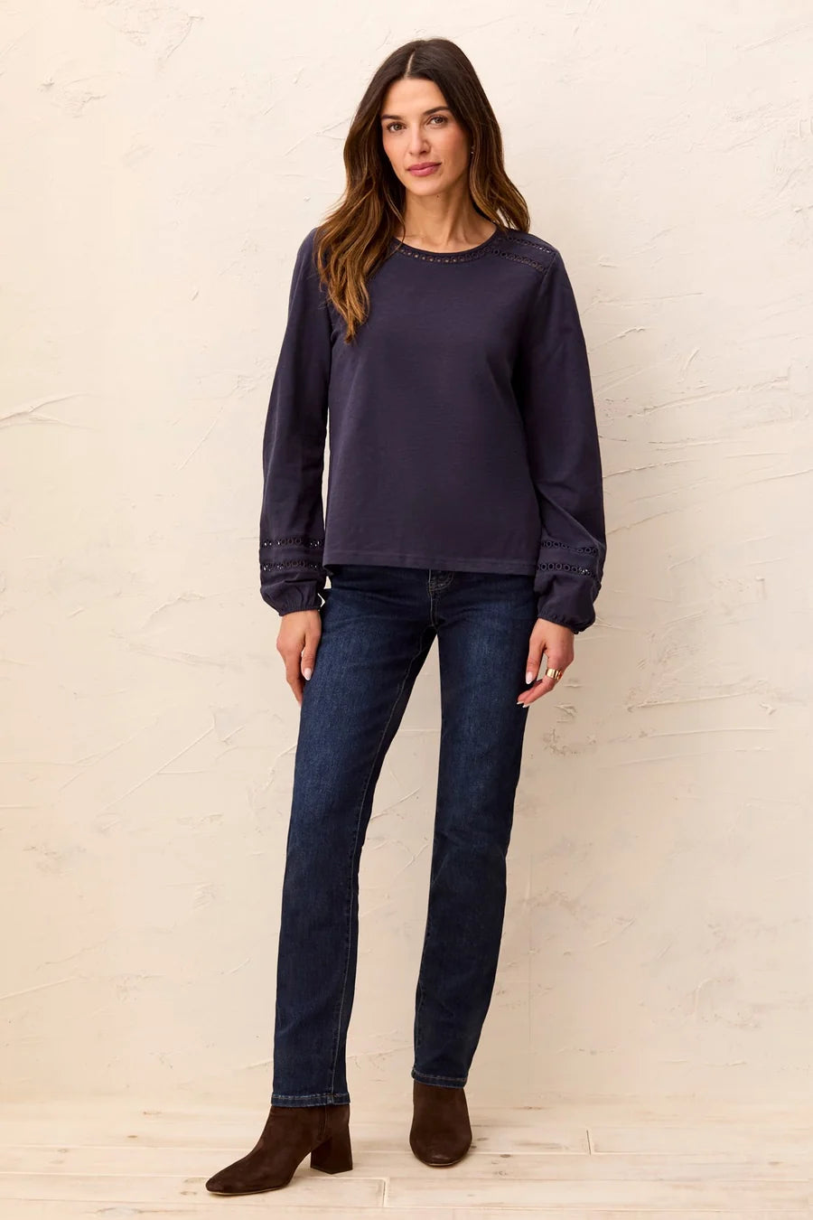 A woman wearing a dark navy blue long-sleeve top with decorative eyelet lace detailing at the neckline and cuffs by tribal Cotton Slub Eyelet Trim Long Sleeve Knit Top
