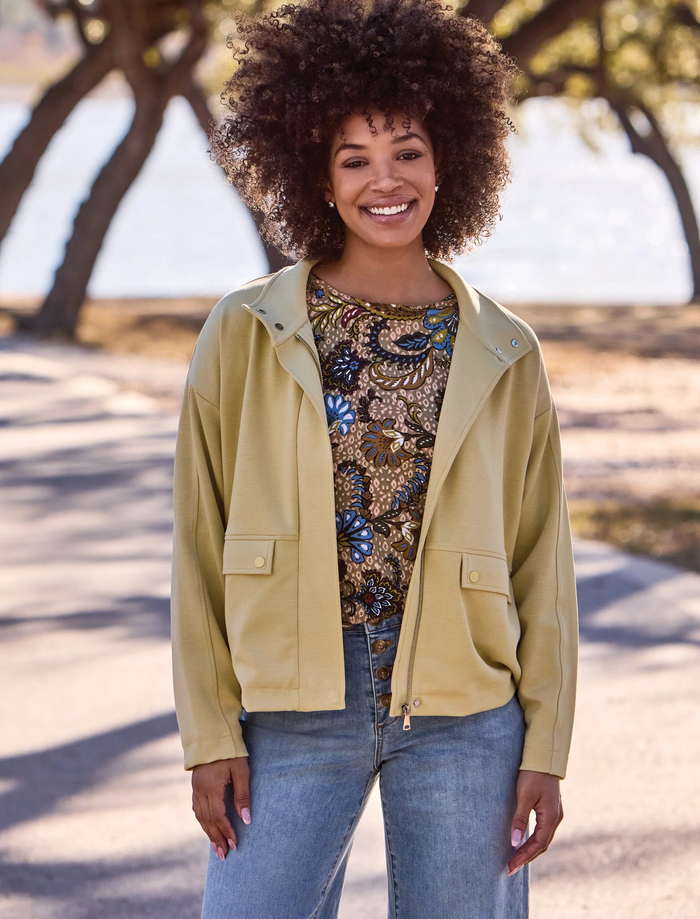 Woman wearing a light green jacket by tribal Soft-Touch Zip-Up Funnel Neck Utility Jacket in the color light pear