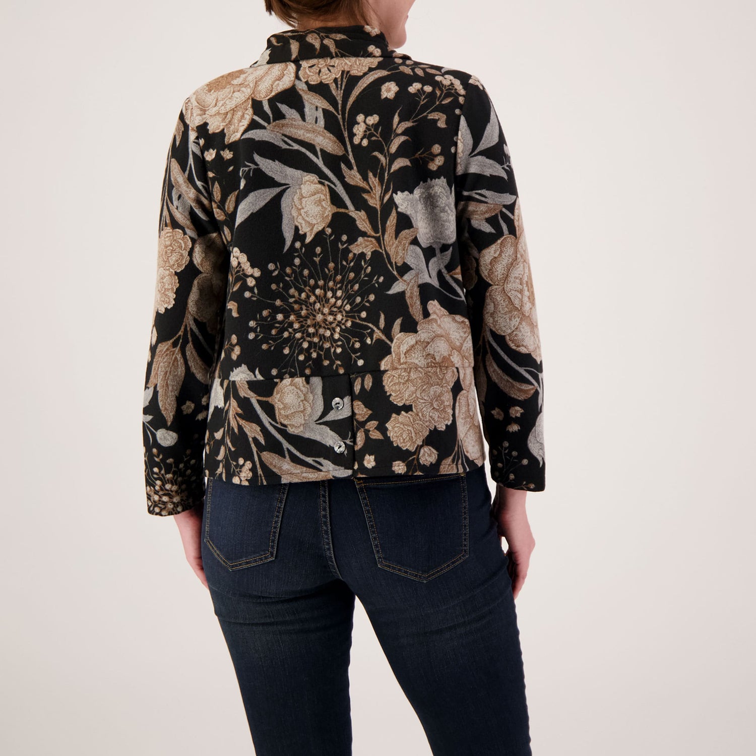 Person wearing a floral patterned jacket on a plain background